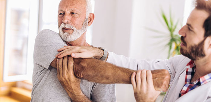 Elderly man receiving shoulder adjustment from Lake Worth chiropractor