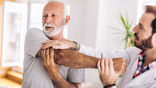 Elderly man receiving shoulder adjustment from Lake Worth chiropractor