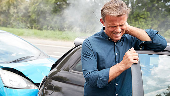 Man with whiplash from auto accident holding his neck in pain before visiting Lake Worth chiropractor