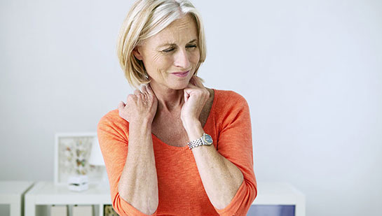 Mature woman suffering from neck and shoulder pain before visiting Lake Worth chiropractor