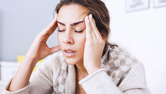 Woman suffering from headache before visiting Lake Worth chiropractor