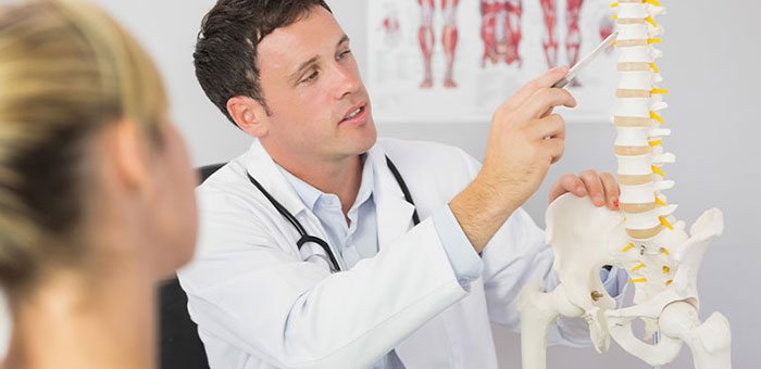 Lake Worth chiropractor explaining spine misalignments to patient